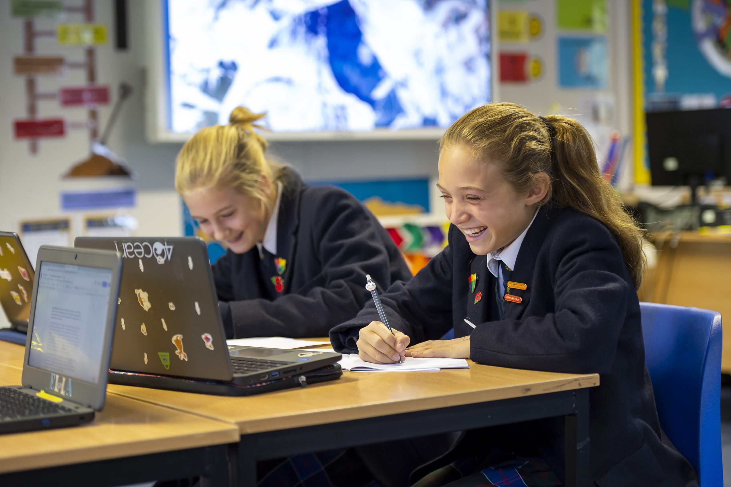 Schoolgirls laughing and enjoying schoolwork