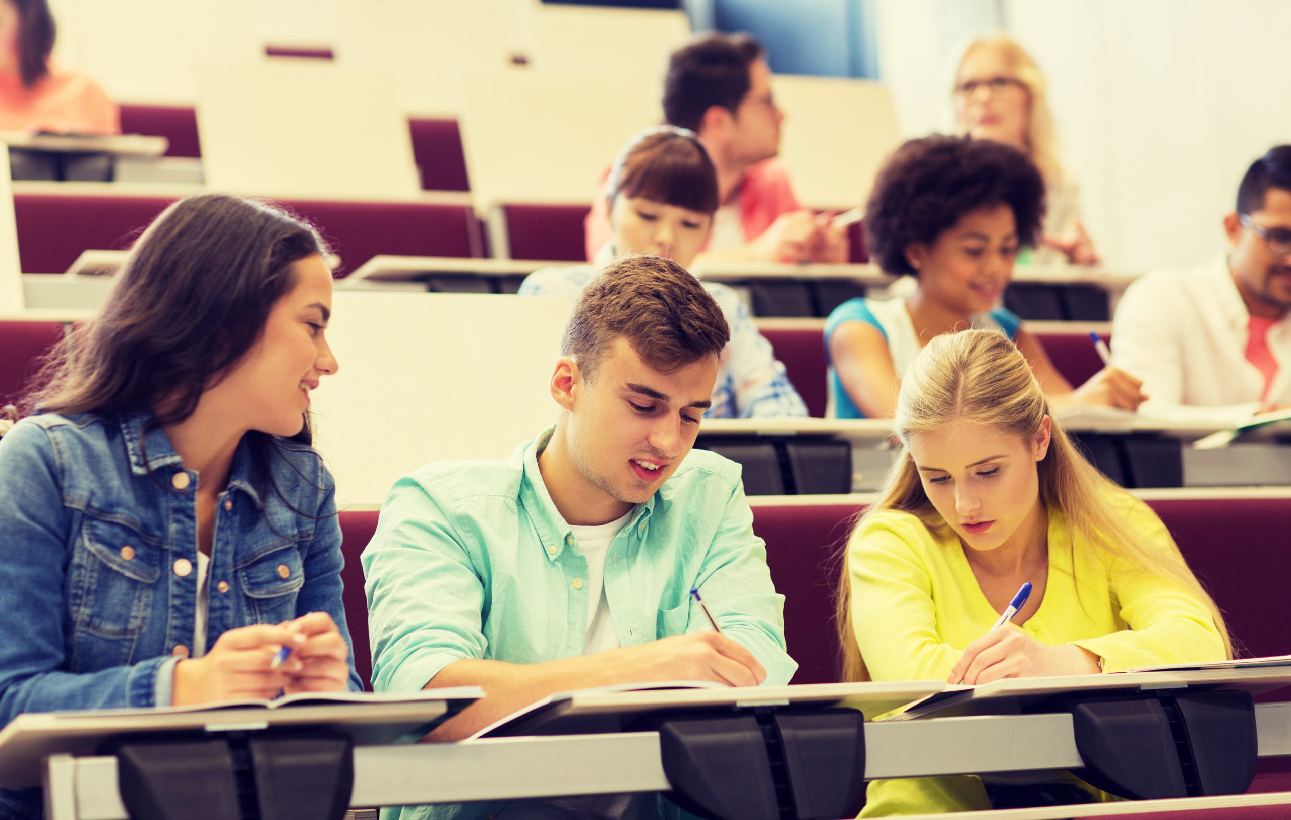 Students in lecture theatre talking and studying